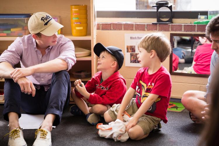 A philosophy student sits with the kids they're tutoring.