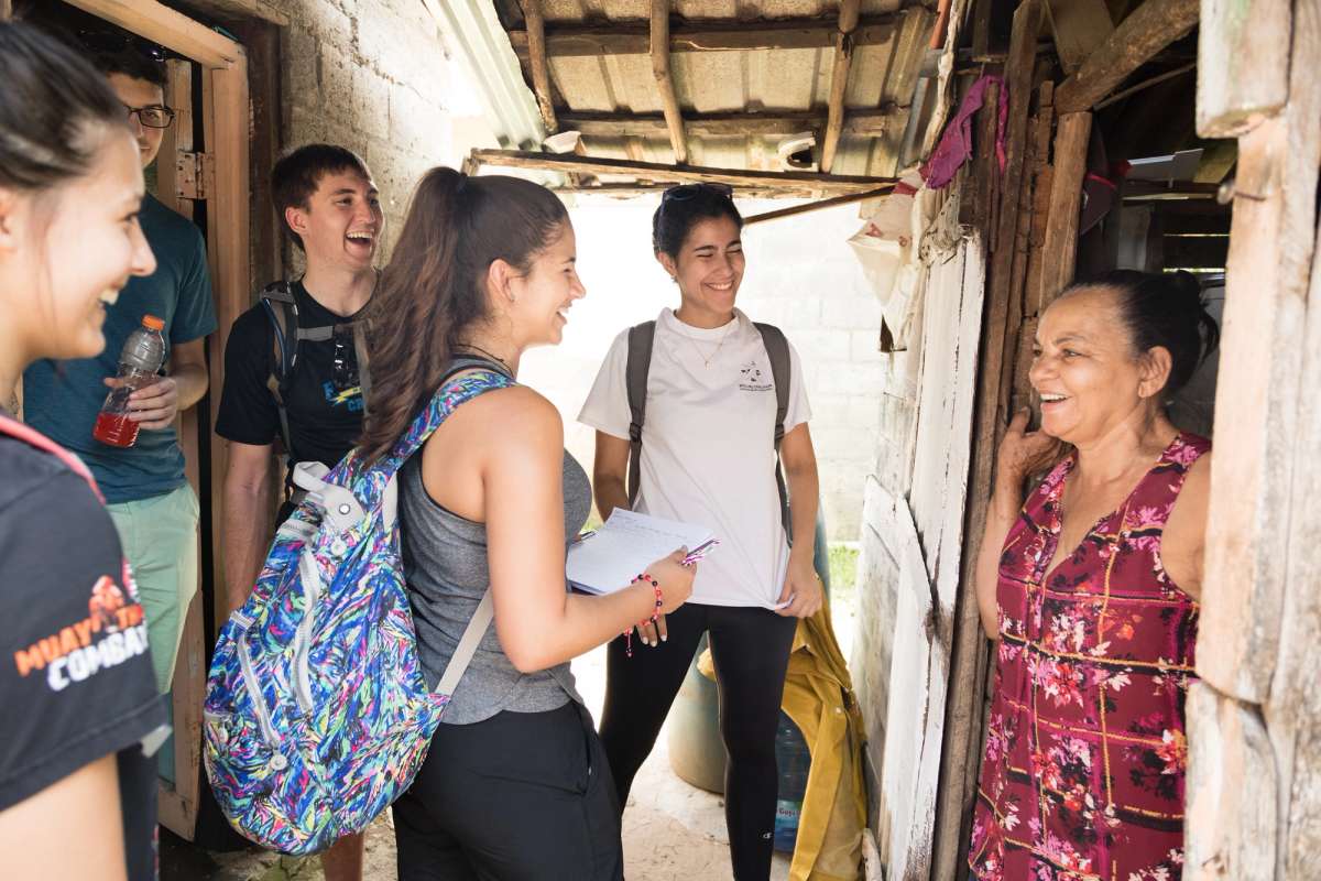 A group of students conduct a survey with a local woman in the Dominican Republic.