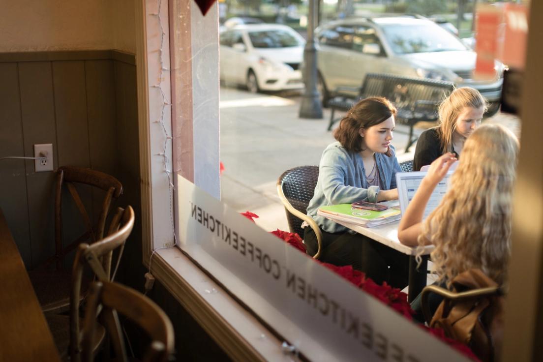 Students sit outside at Barnie’s CoffeeKitchen collaborating on blog content for the company’s website.