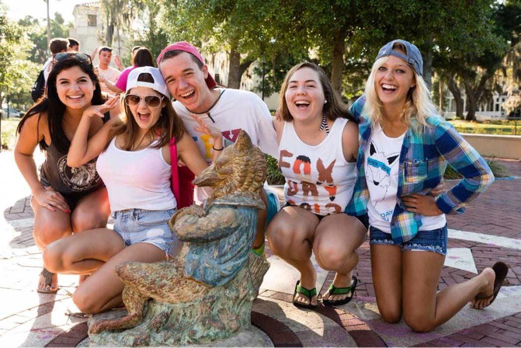 Students pose with the wooden fox statue representing Fox Day. 