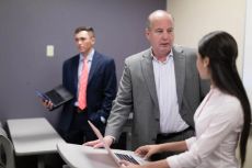 Business professor consults with a student in class.