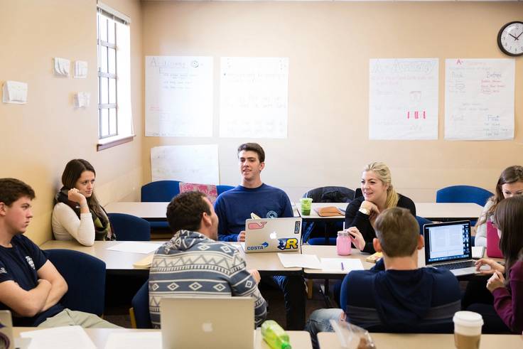 Professor Phil Kozel's students at their desks with their computers open discussing Mysteries and Marvels of Piracy.