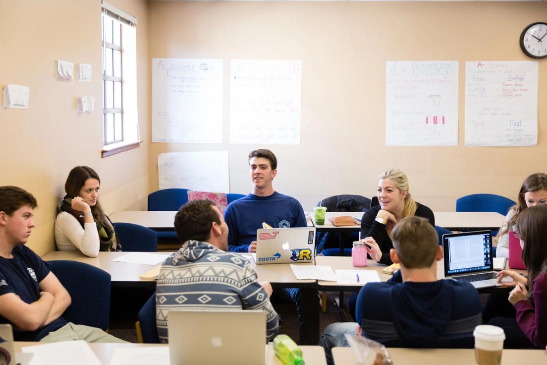 Professor Phil Kozel's students at their desks with their computers open discussing Mysteries and Marvels of Piracy. 