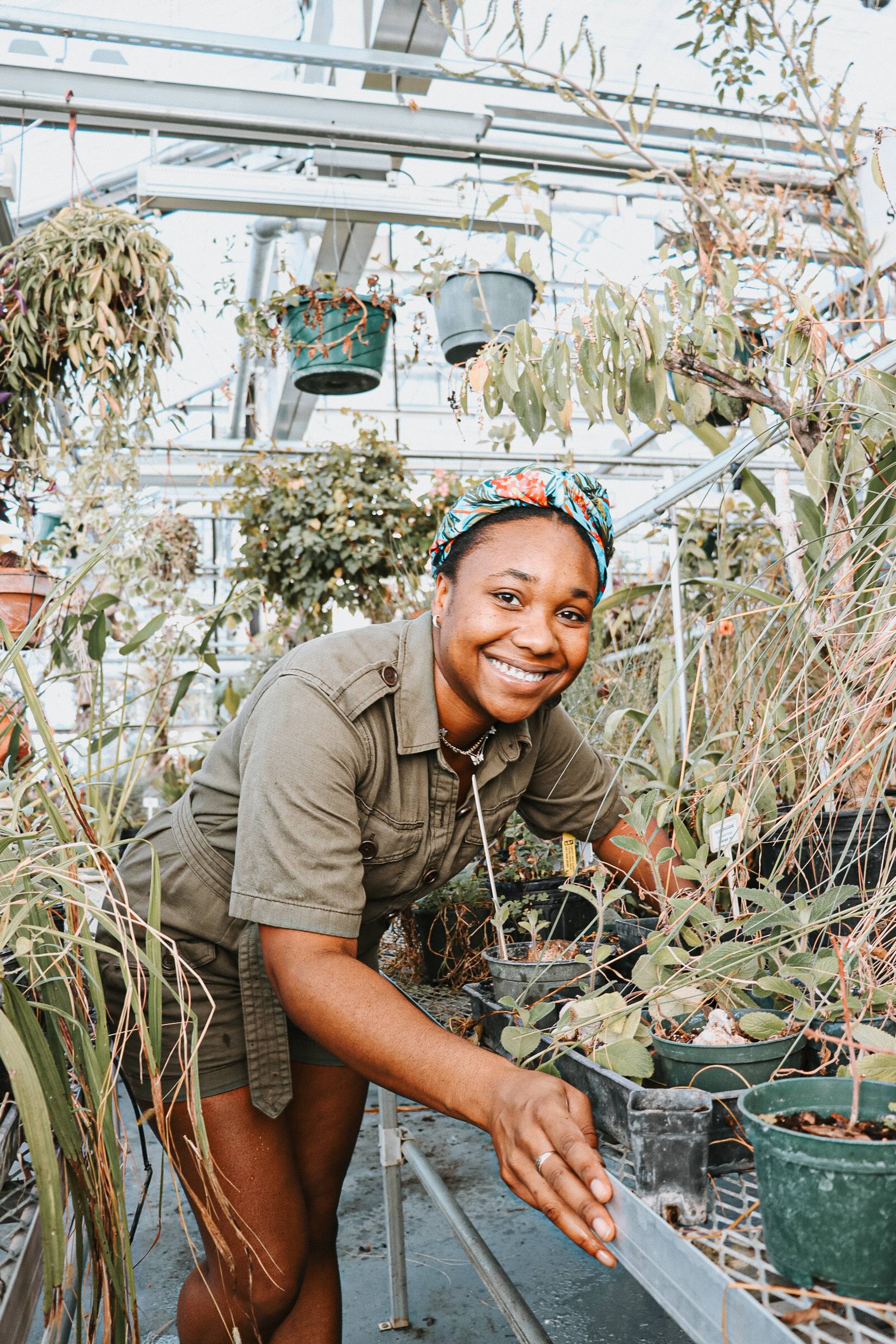 Photo of Zari St Jean working in the Rollins greenhouse.