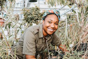 Photo of Zari St Jean working in the Rollins greenhouse.