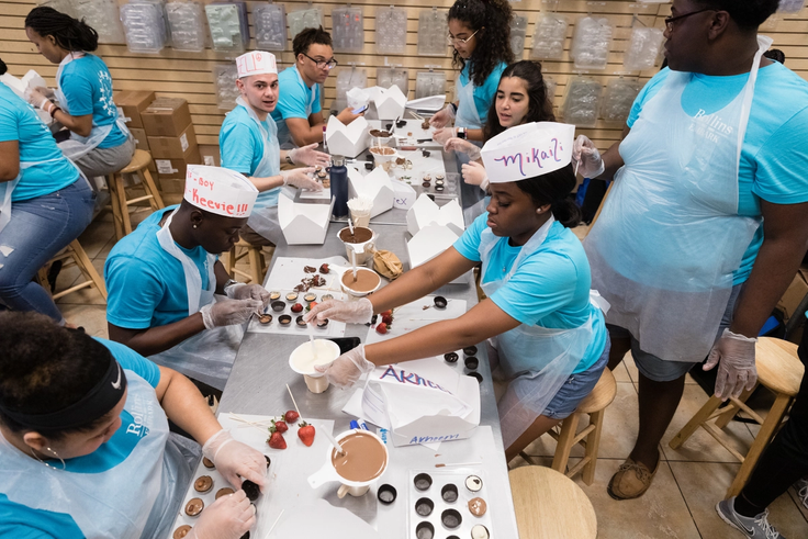 Students making chocolates together at Farris and Foster’s Chocolate Factory during orientation.