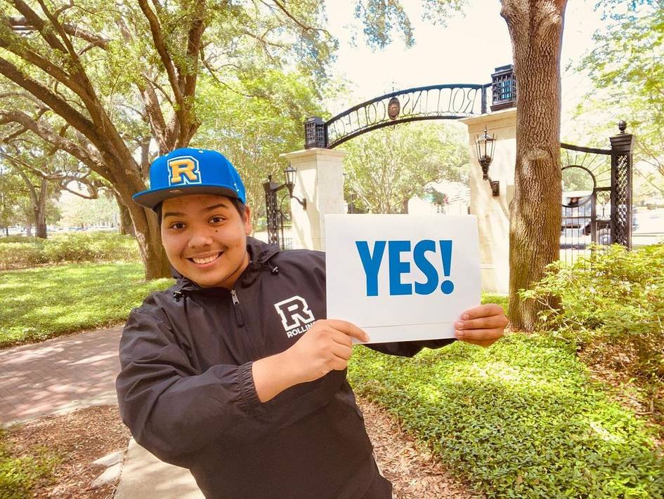 A high school student holds up his letter of acceptance to Rollins.