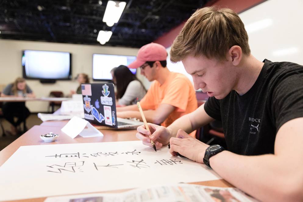 A Rollins student practicing Chinese calligraphy.