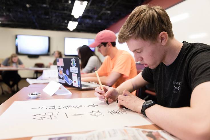 A Rollins student practicing Chinese calligraphy.