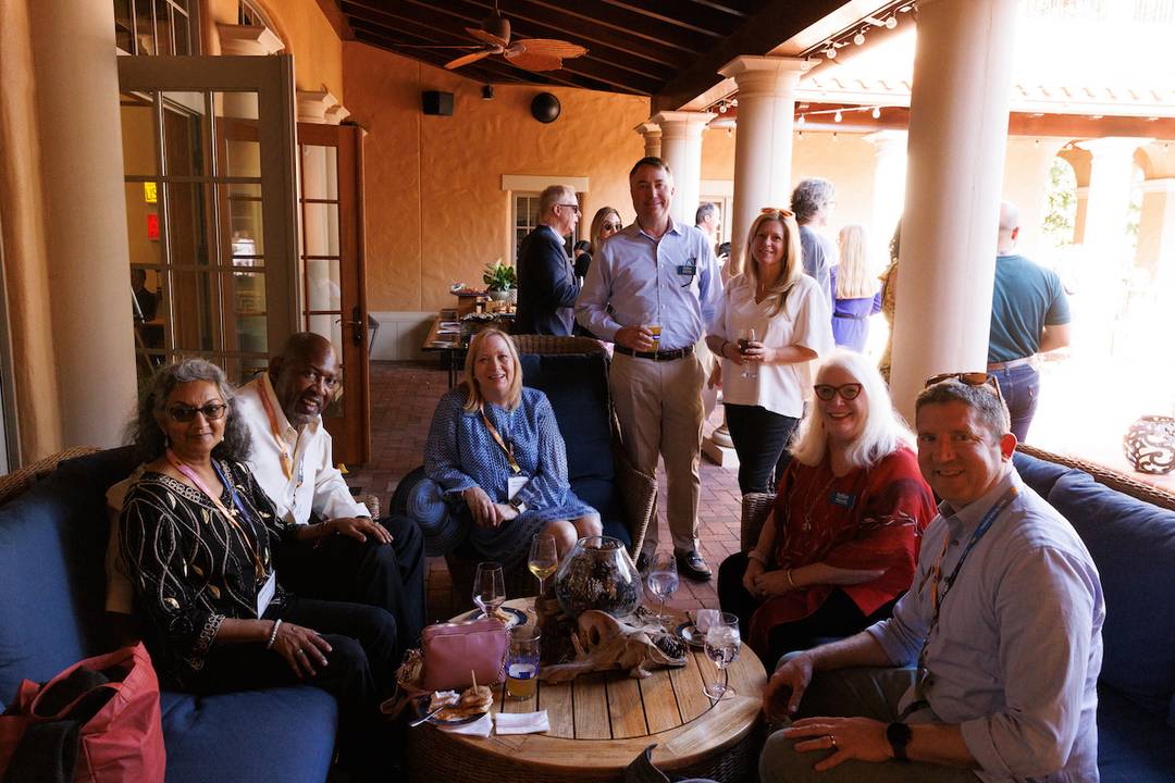 Rollins Alumni Weekend 50th Reunion Welcome Reception at the Barker House with seven alumni sitting and chatting.