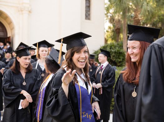 Students in cap and gown, celebrating Commencement.