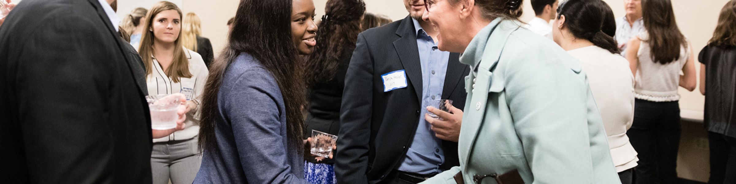 Group of young professionals shaking hands with an executive.