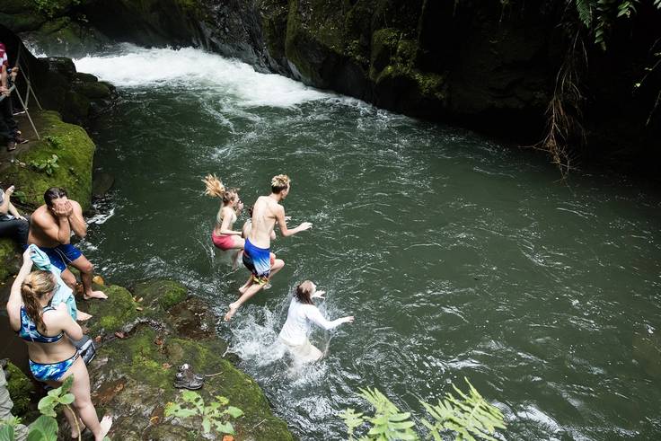 Students jumping from a cliff into the water in Costa Rica.