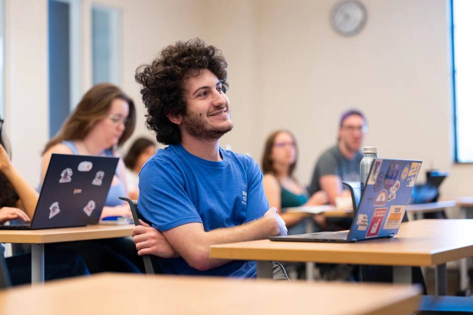A student smiles at his professor during class.