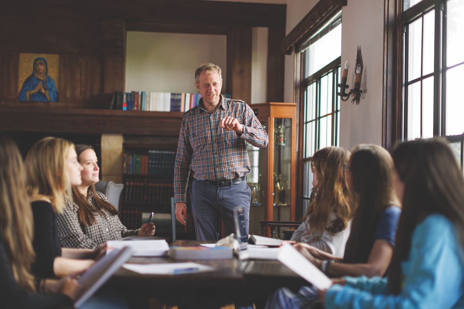 A professors leads a discussion with a small class of students.