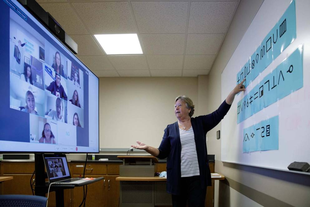 A masked professors teaches a virtual class during COVID-19