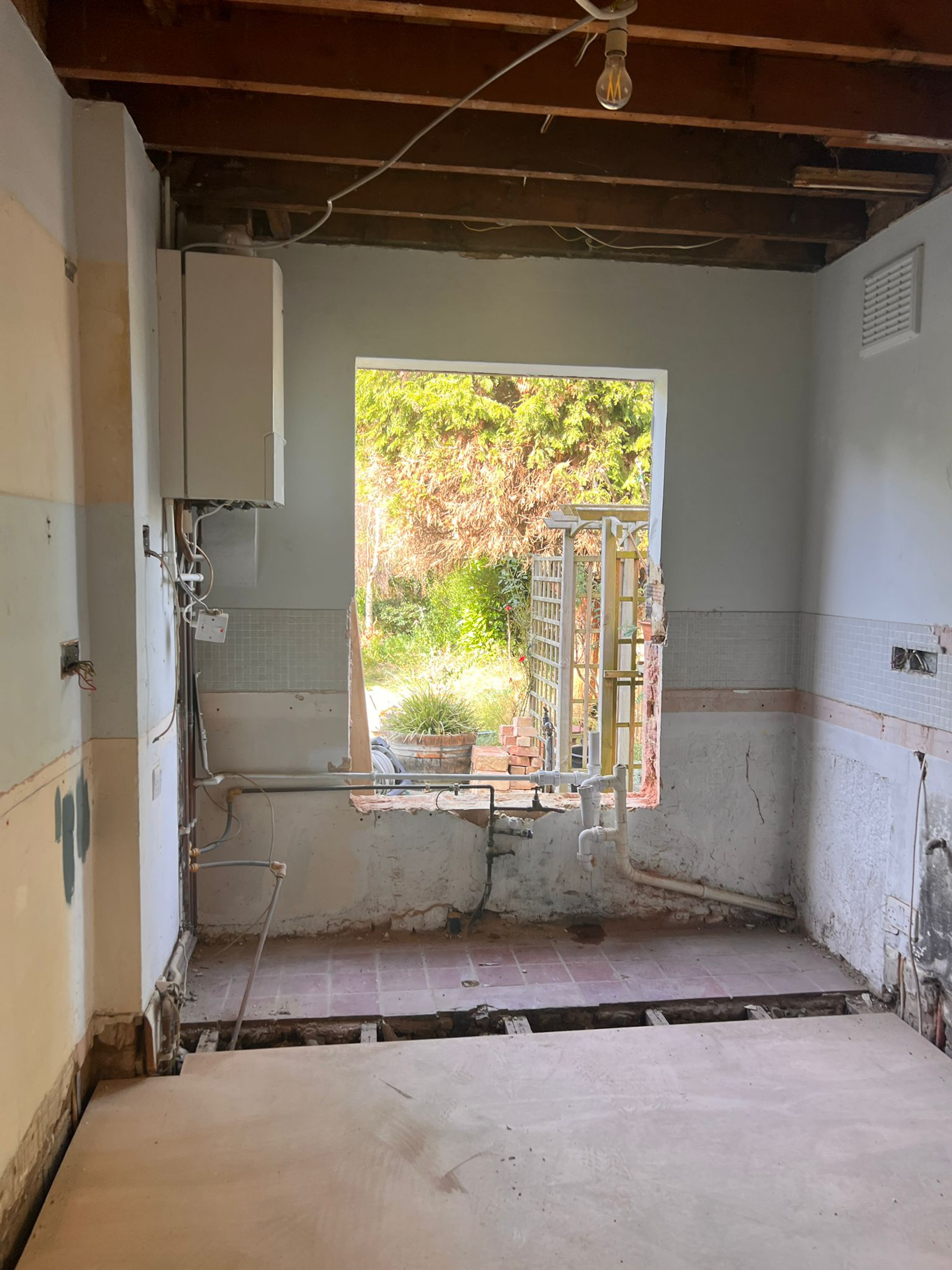 Photo of enlarged window opening in wall.