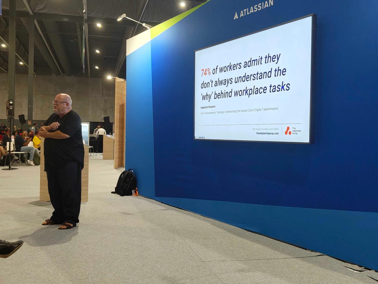 Michael Rudenko standing on stage presenting a talk