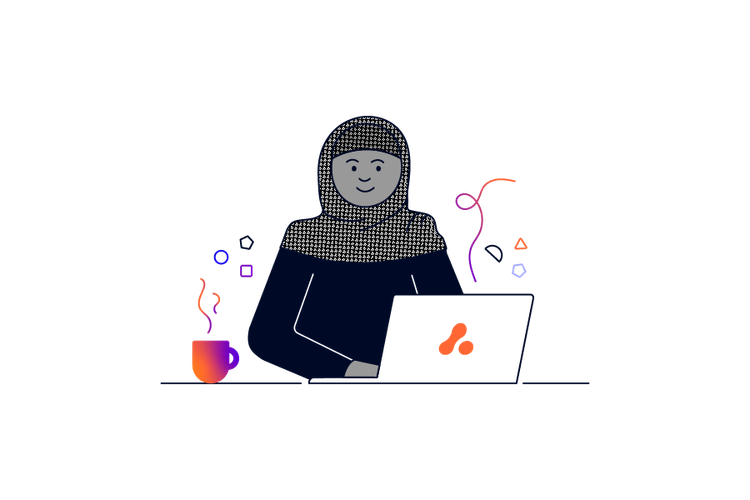 A person wearing a headscarf sitting in front of an Adaptavist Group laptop with a hot drink next to them