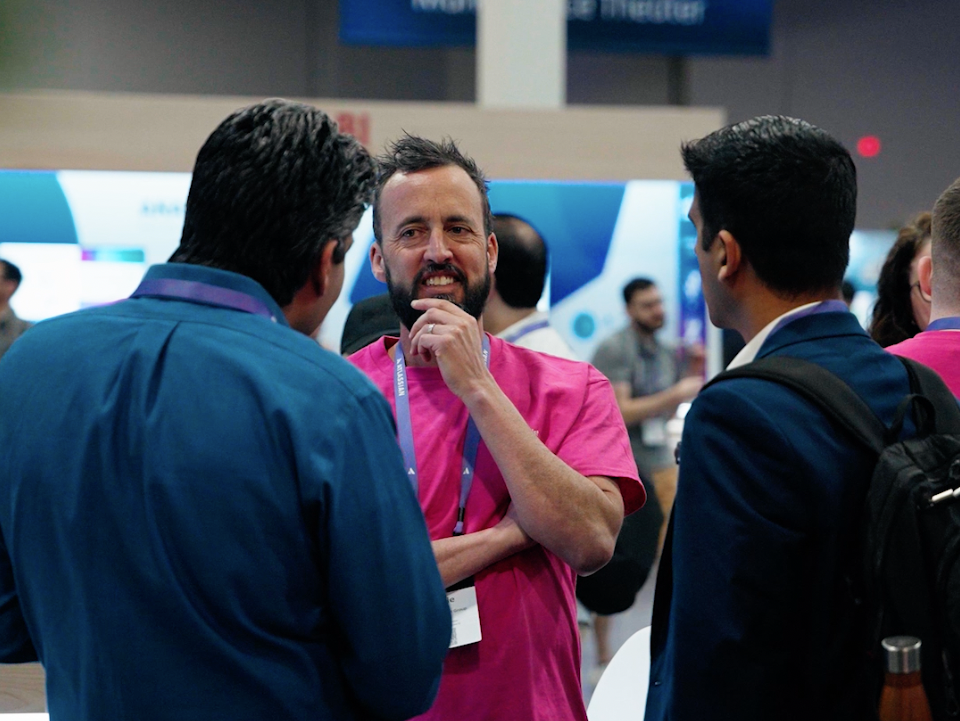Jamie from ScriptRunner chatting to two people at an event