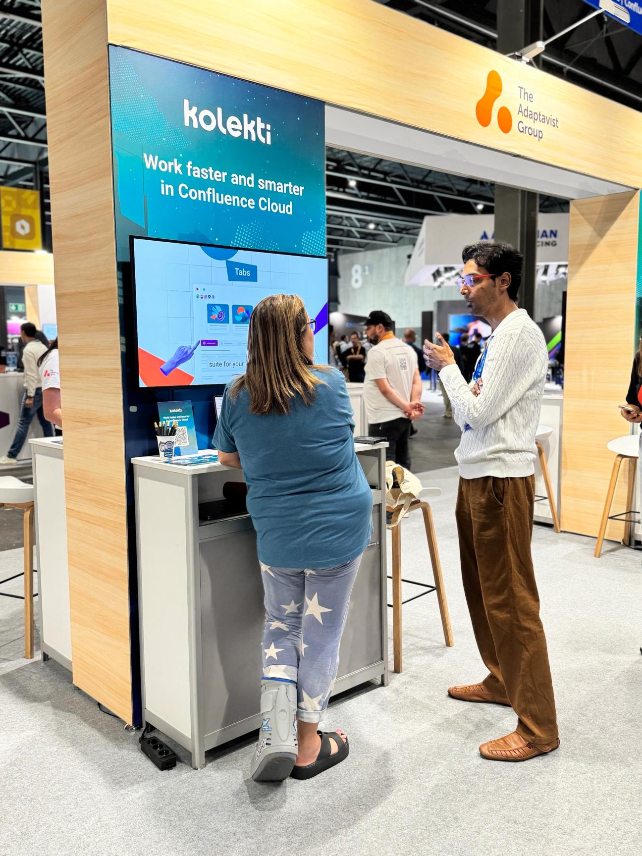 Two people standing at Kolekti's Team '25 Europe booth