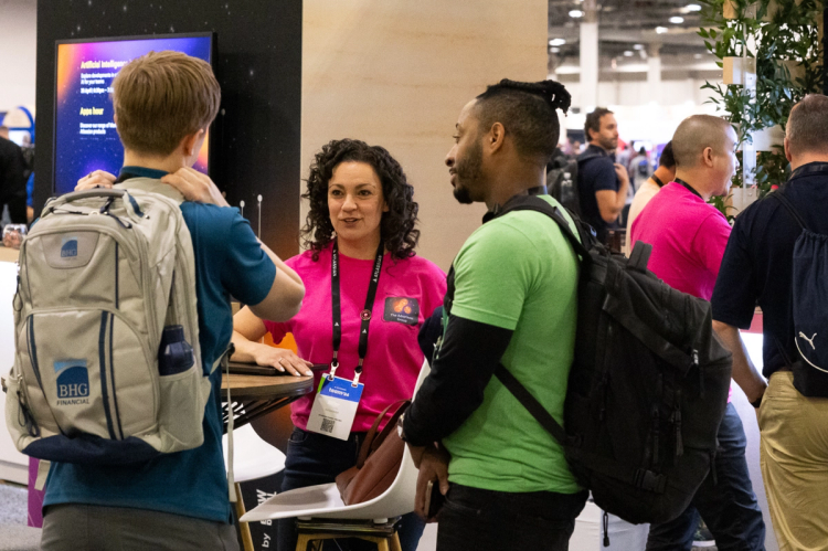 People having a discussion around The Adaptavist Group's booth at an event