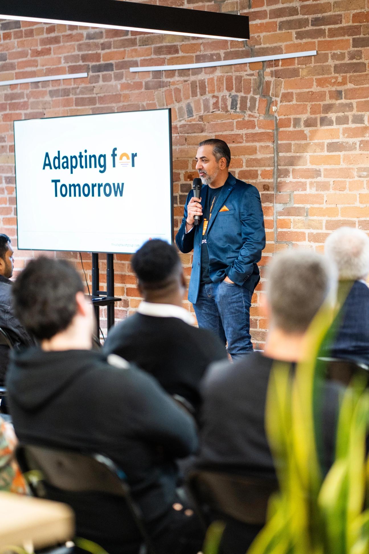 Harp Athwal standing in front of audience holding a microphone