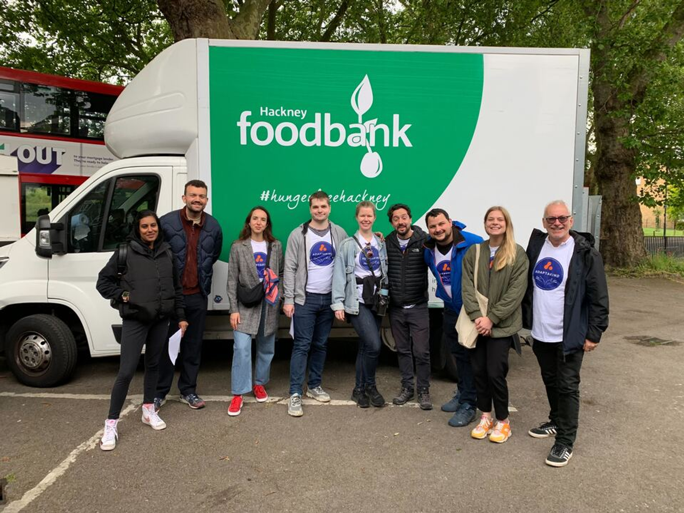 Members of the ScriptRunner team wearing AdaptaKind t-shirts standing in front of a Hackney Food Bank van.