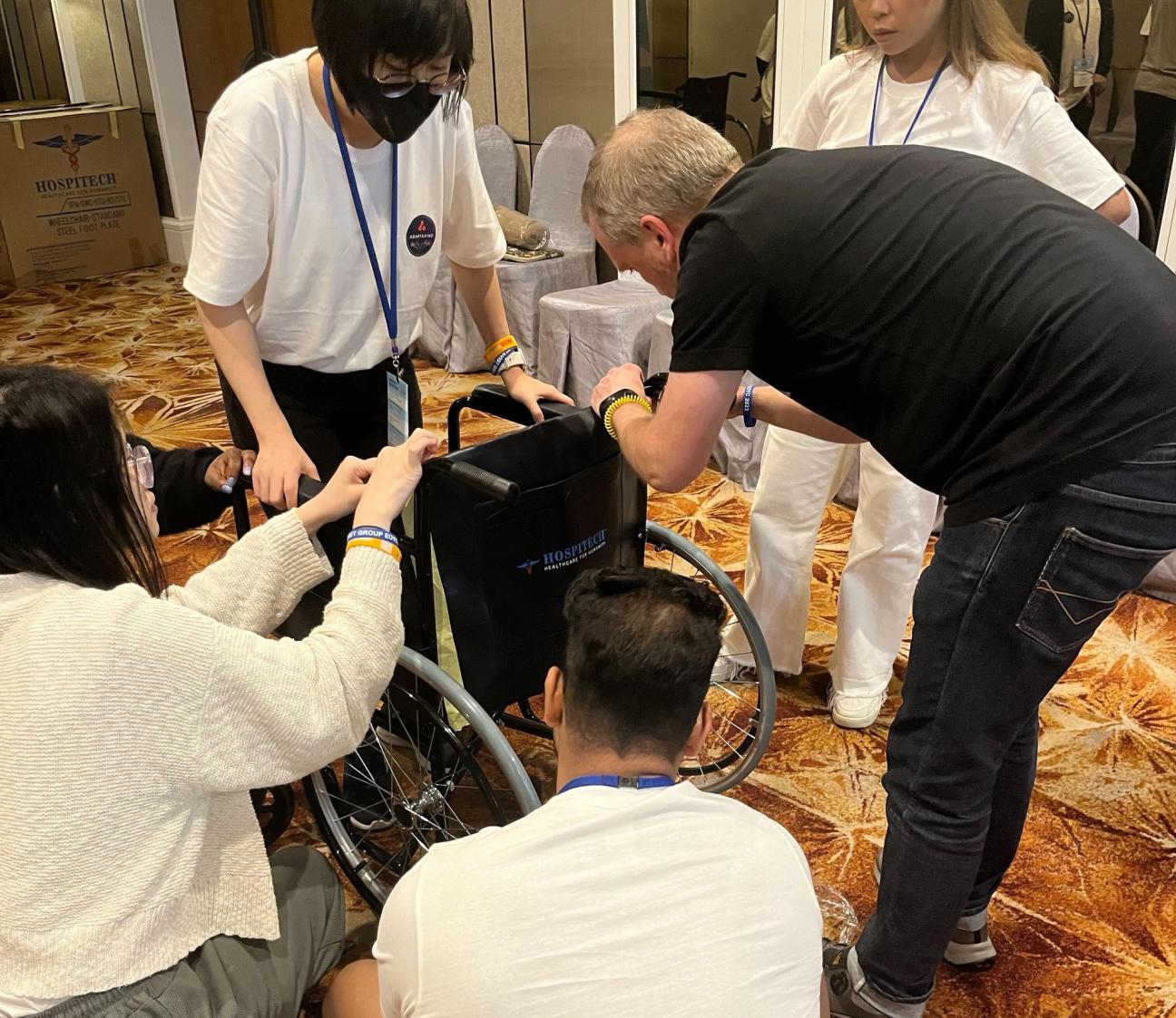 Team members gathered around assembling a wheelchair