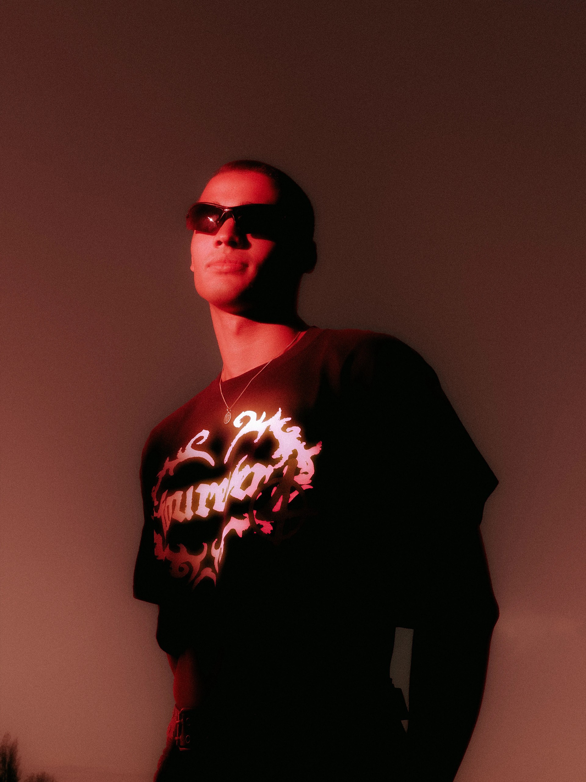 Model lit in deep red, the fourever heart graphic glowing on the chest