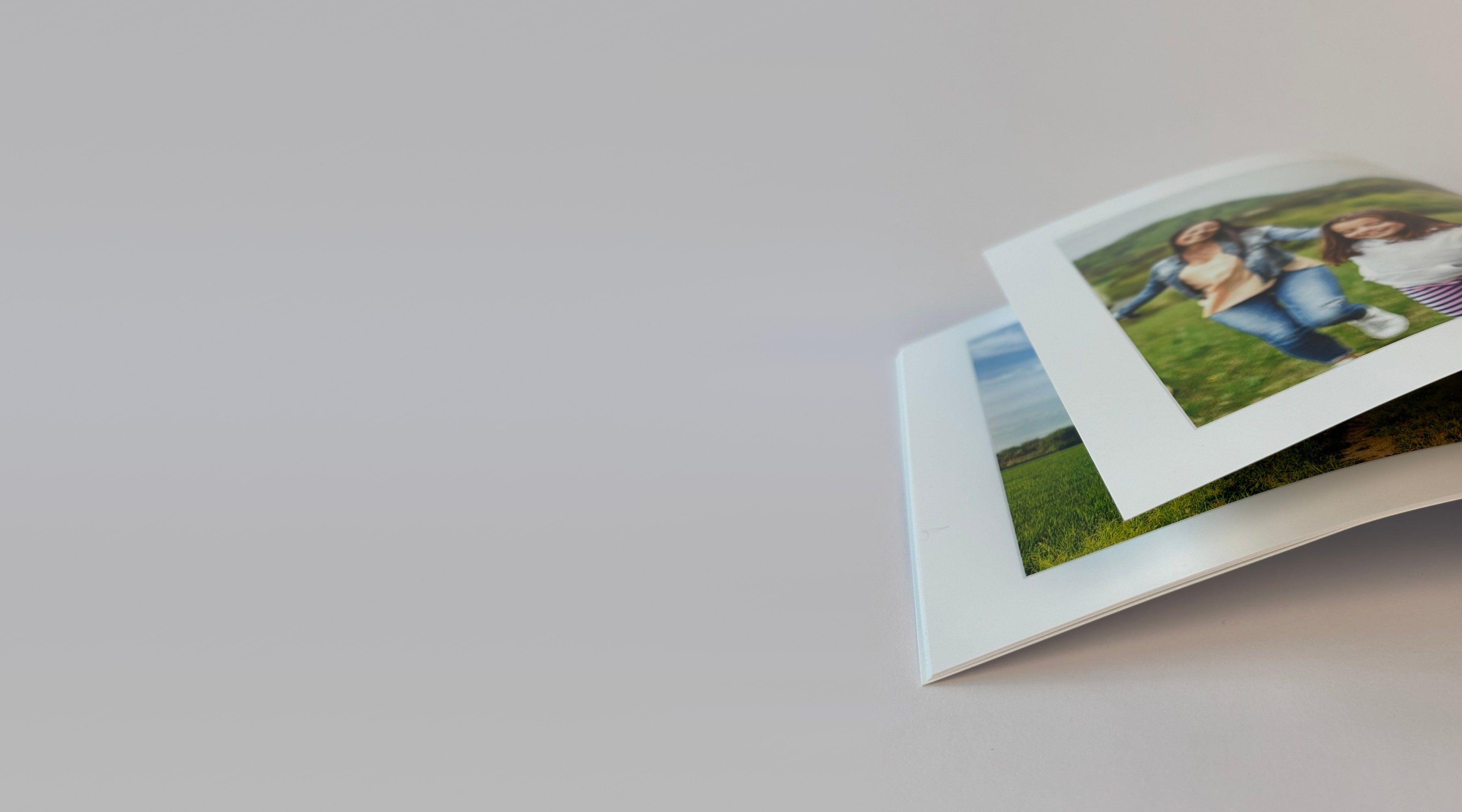 An open photo album with photos of girls in a green field