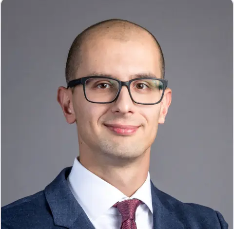 Headshot portrait of Jurij Skornik, General Manager at Trace Labs (OriginTrail core devs), in a suit and tie, smiling.