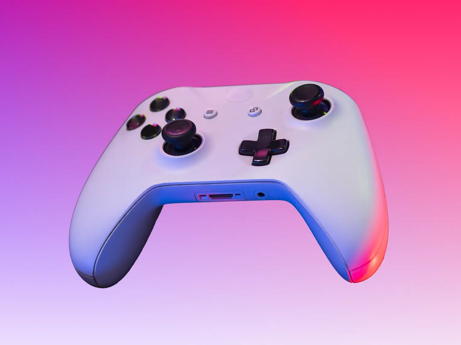 Gaming controller on a pink Polkadot-brand gradient background