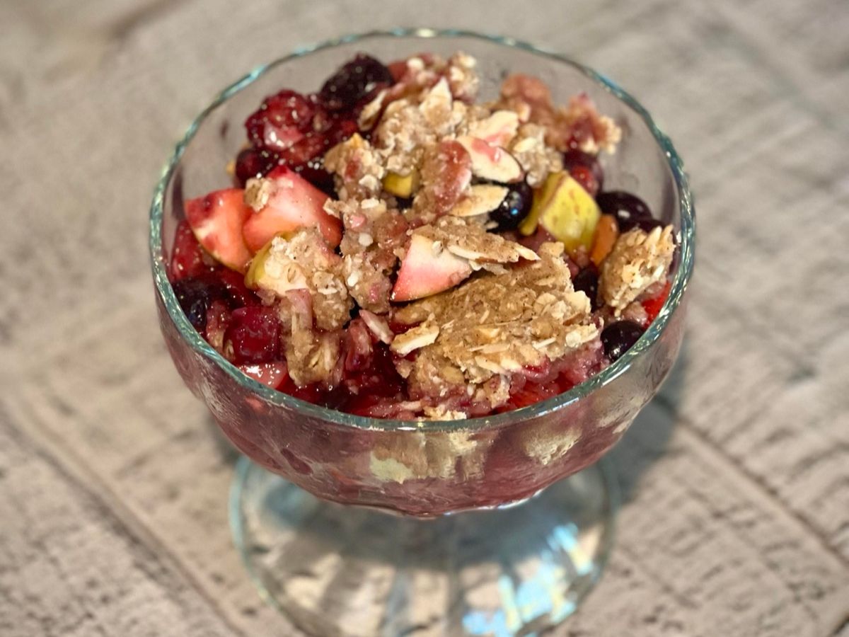 A baking dish of fruit crumble with a golden oat topping