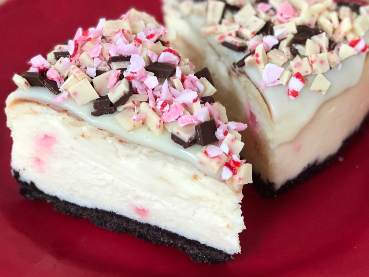 A slice of white chocolate peppermint cheesecake garnished with crushed peppermint