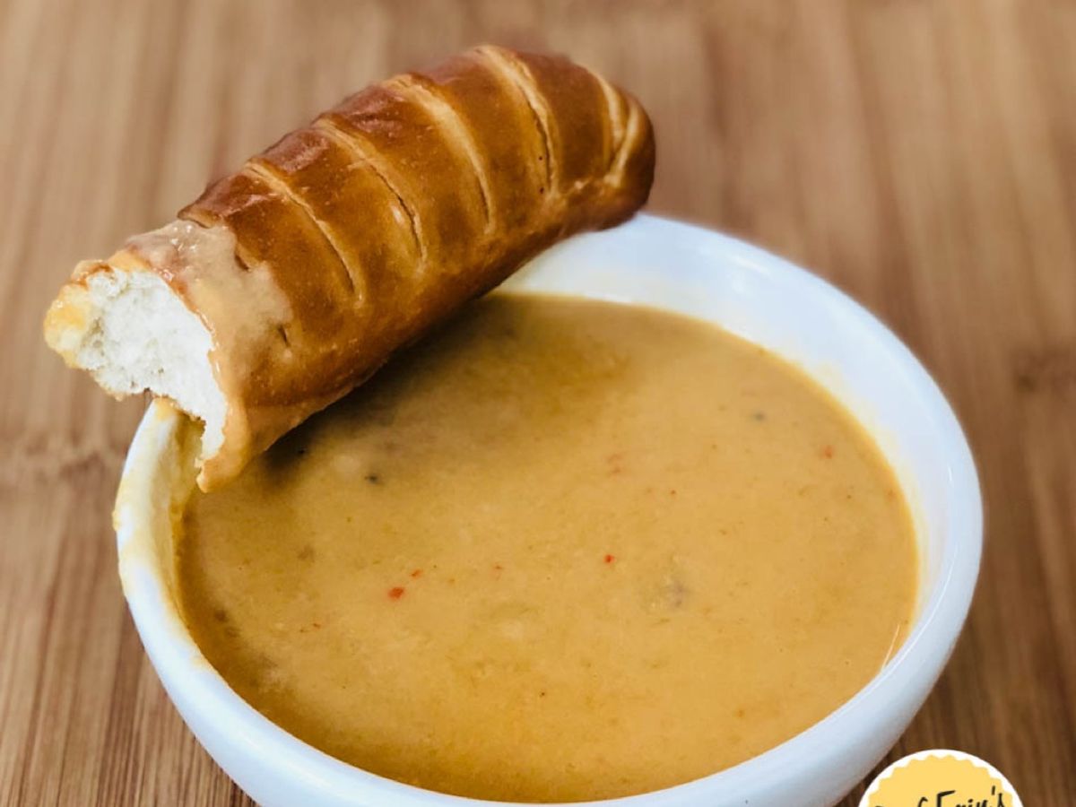 A bowl of thick beer cheddar soup with sausage