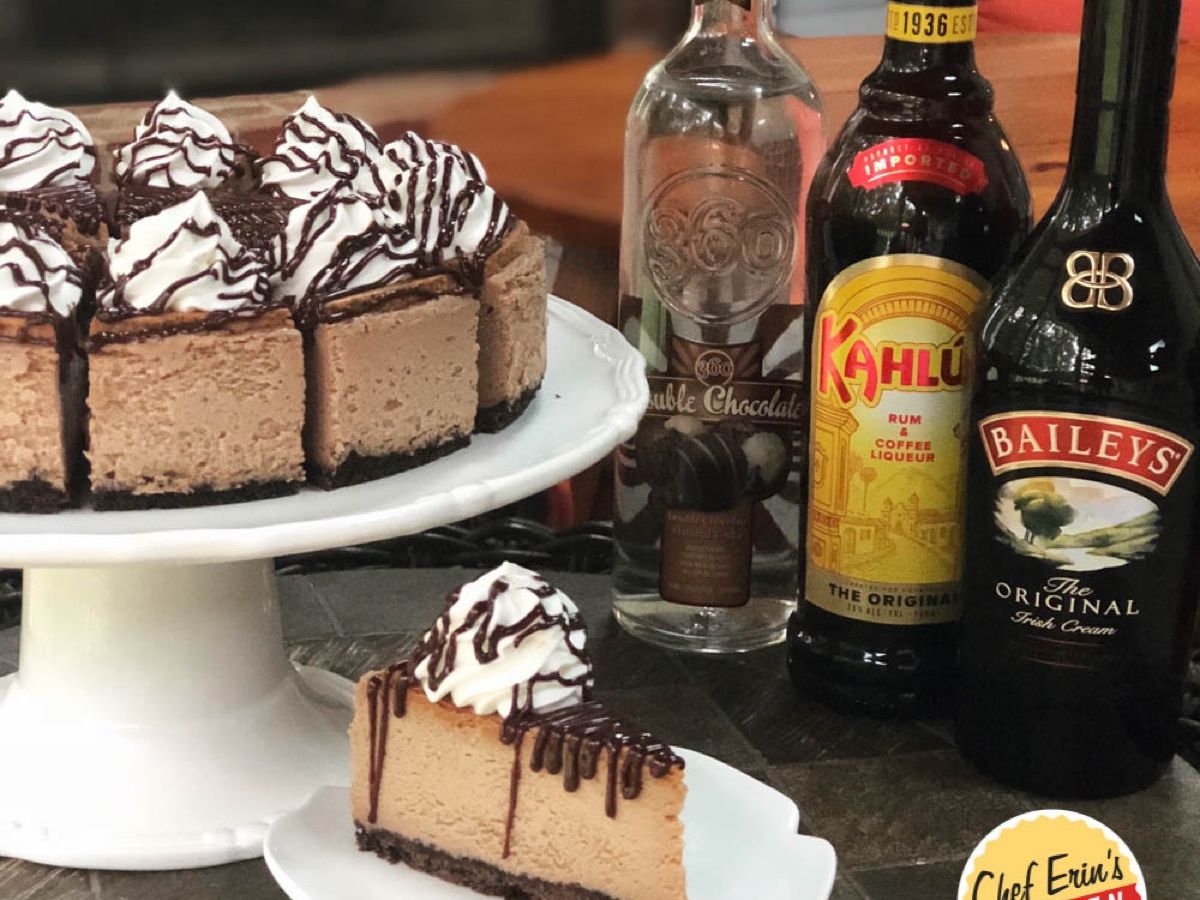 A slice of mudslide cheesecake drizzled with chocolate ganache and whipped cream