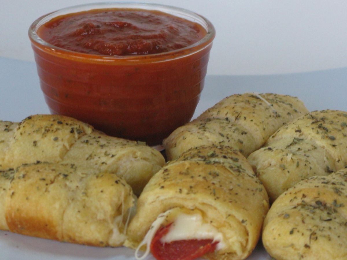 A baking dish of golden baked pizza rolls