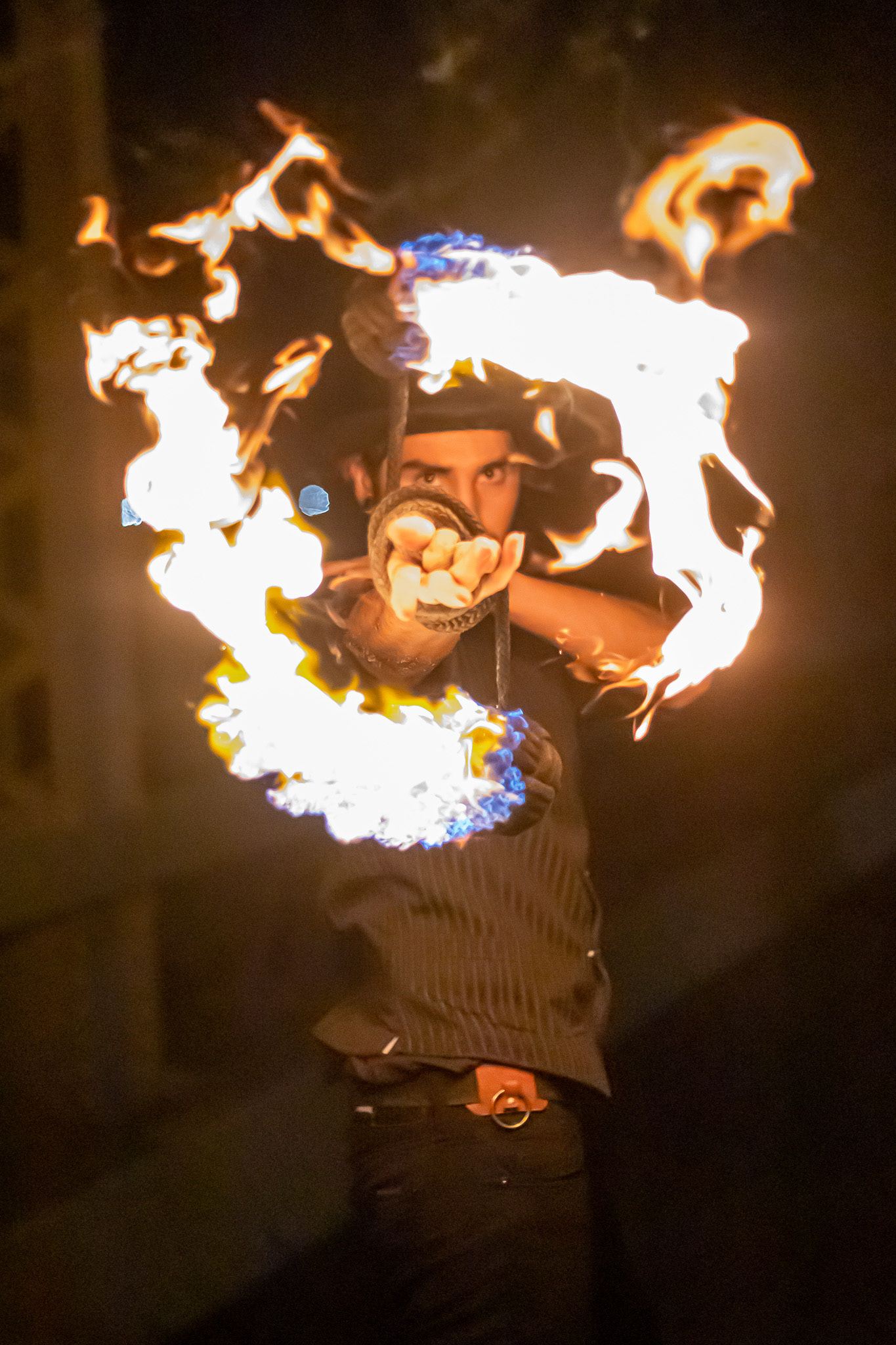 Fire performer at night with flames framing the performer’s face