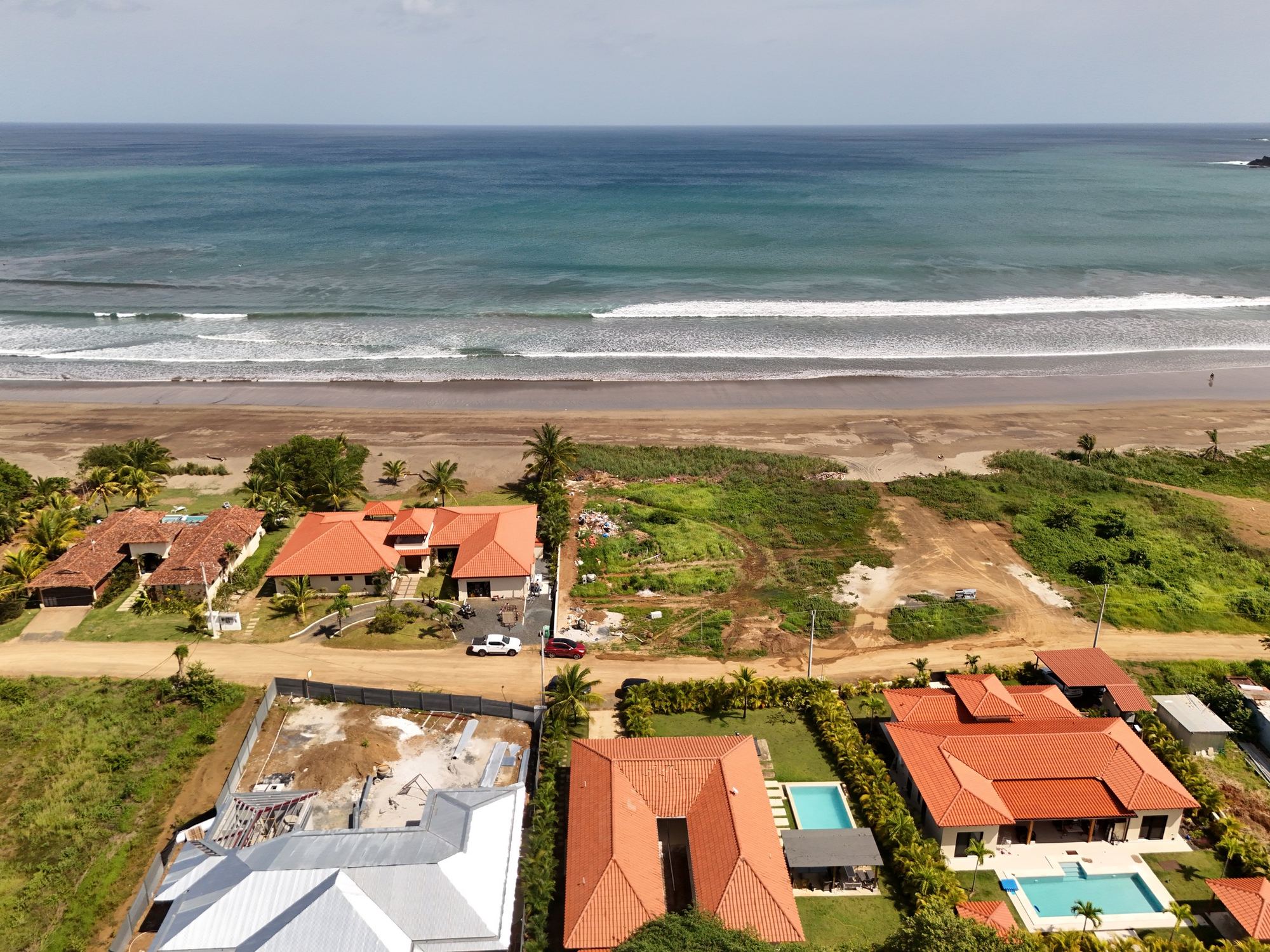 Beachfront houses along the surf at Playa Venao, seen from above the water