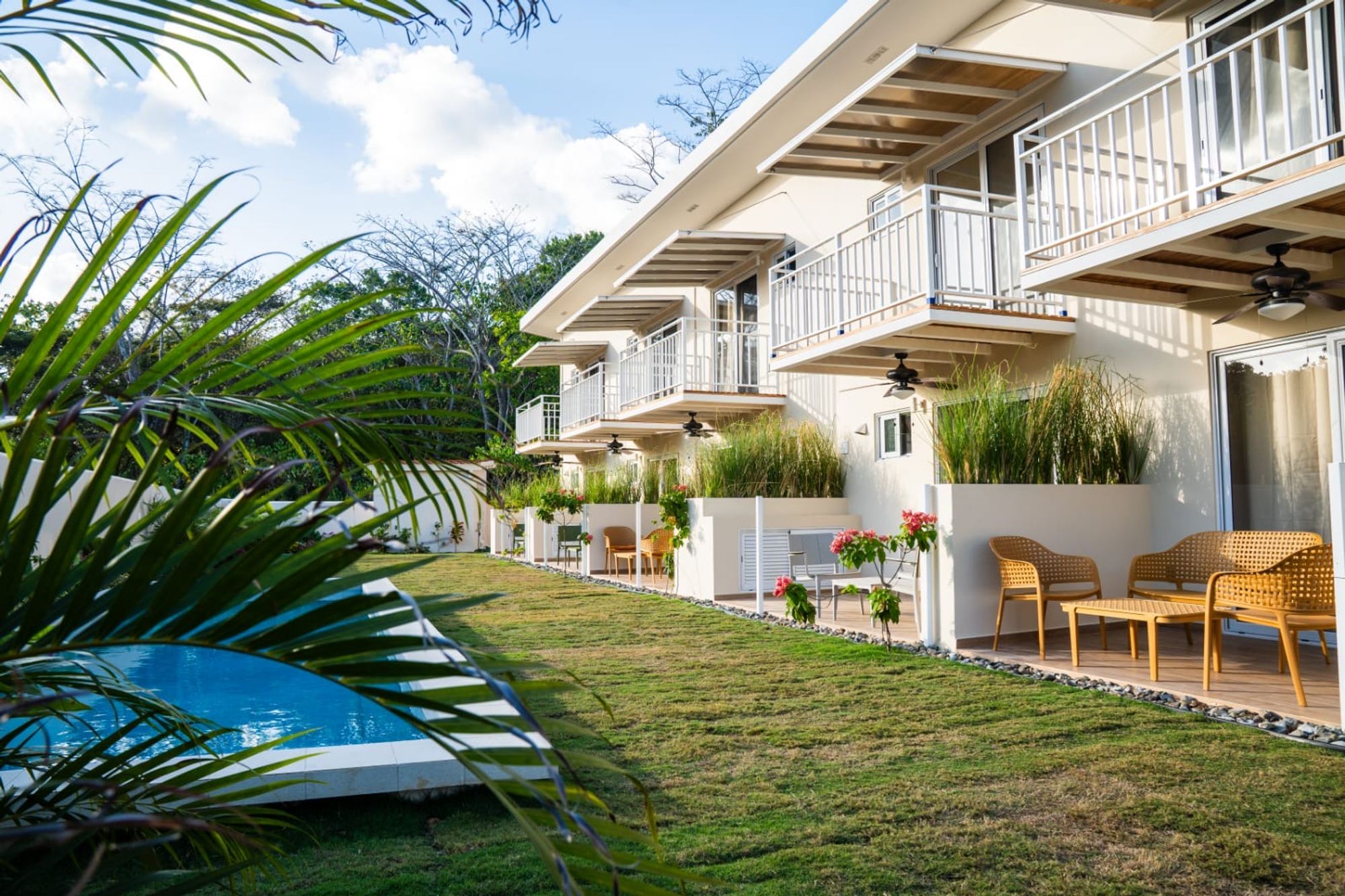 Exterior of the Cozy Venao building with balconies over a lawn and pool