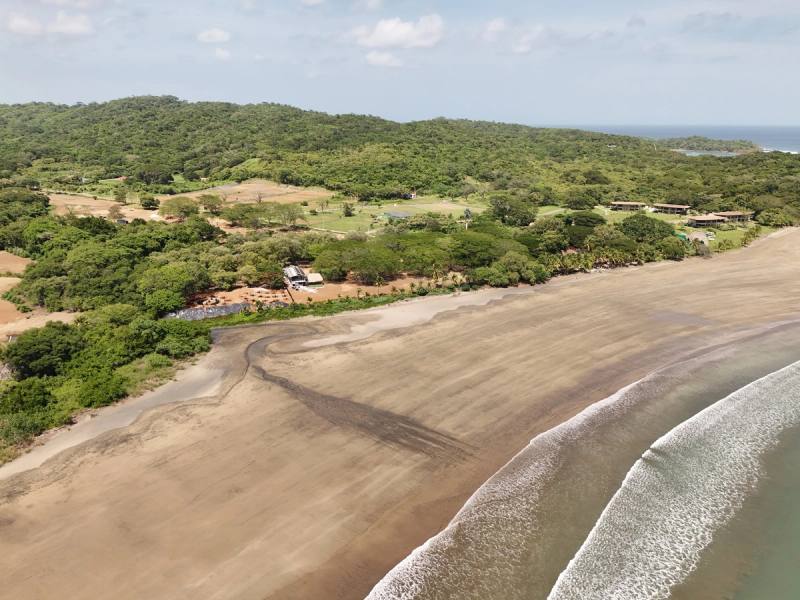 The beachfront strip with the headland behind