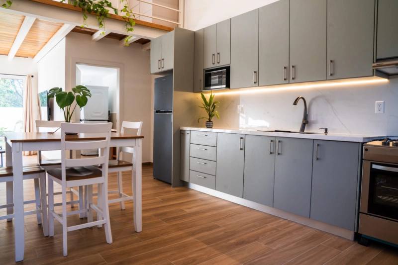 Kitchen with grey cabinetry, oven and a dining table for four