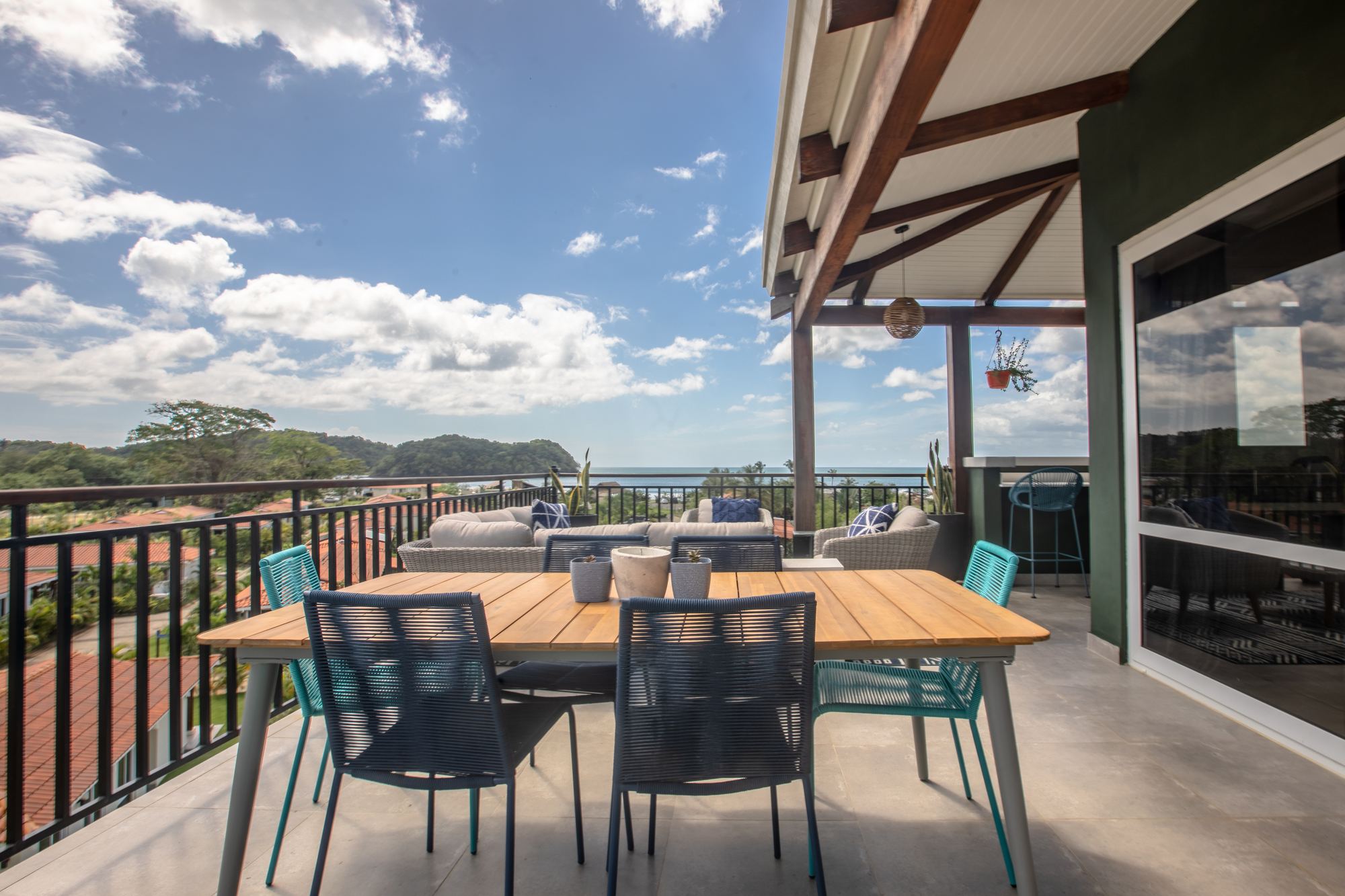 Terrace of the Blue Venao penthouse with a table set for six, looking along the bay
