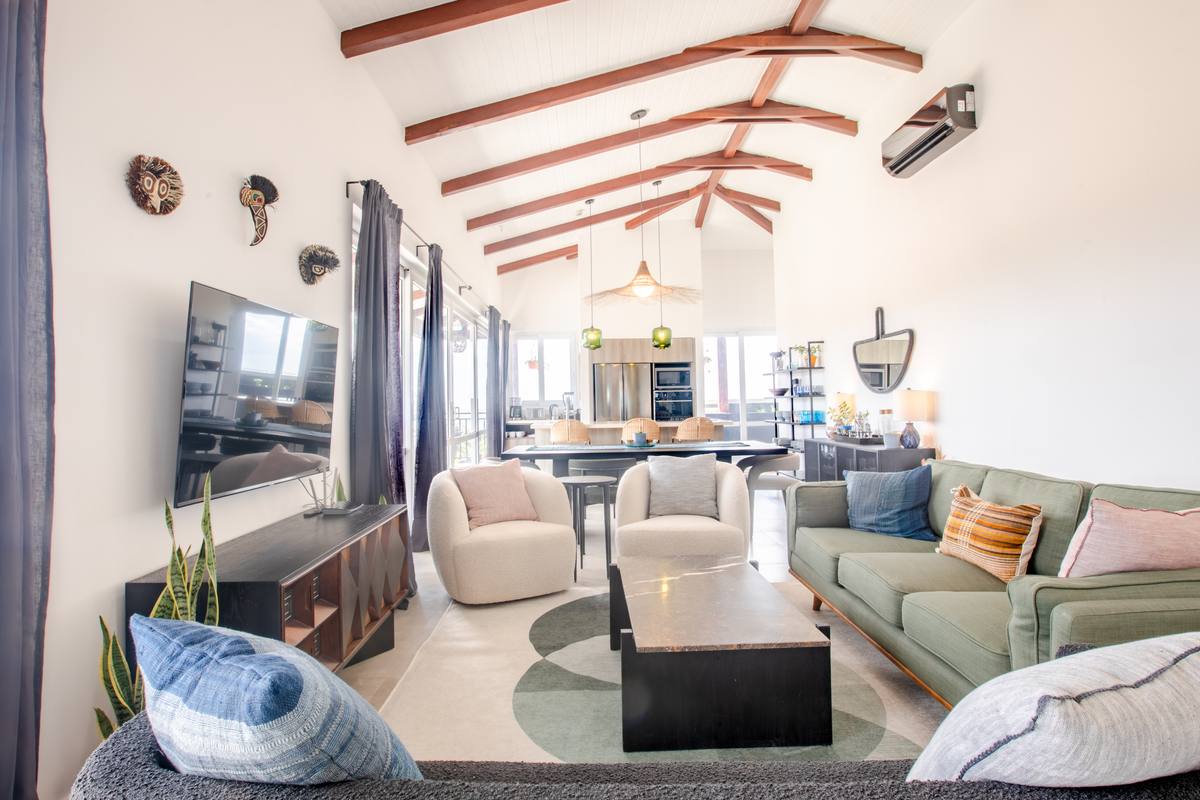 Living room under a vaulted timber ceiling, open to the dining area