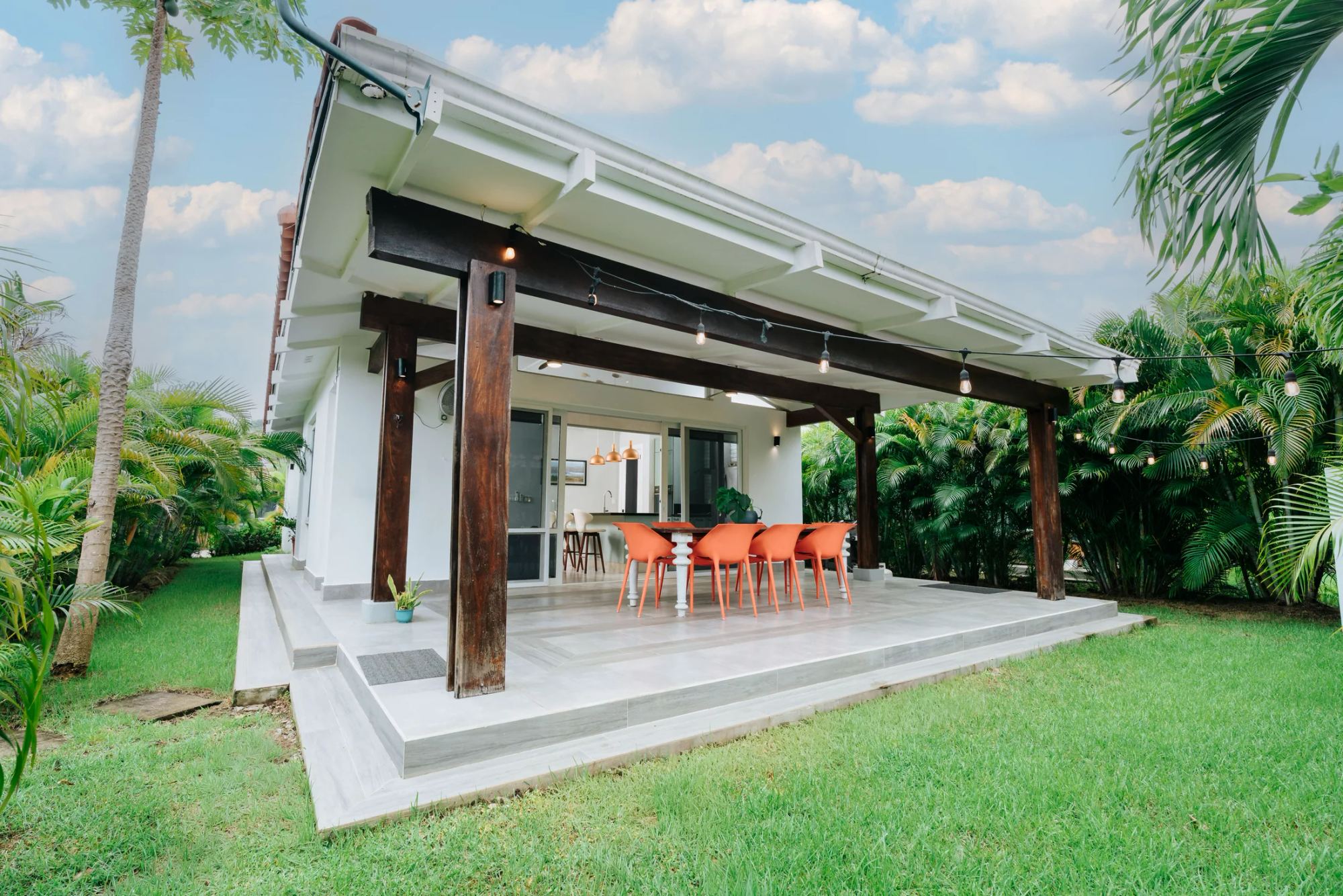 Casa y terraza cubierta rodeadas de jardín en Blue Venao