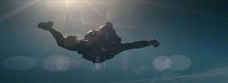 Skydiver in freefall silhouetted against the sun, captured on Kodak 16mm film.