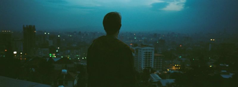 Silhouette of a person overlooking an Ethiopian city at twilight.