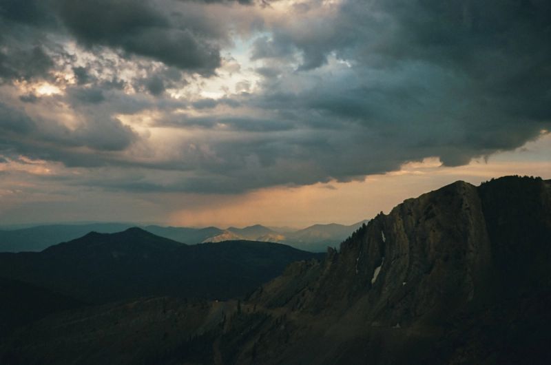 Dramatic mountain landscape in Utah Snowbird with stormy clouds and golden light.