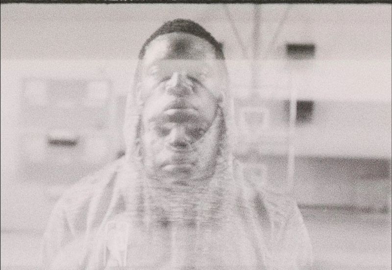 Reggie Jackson gazing through a window pane in grainy black and white film photography.